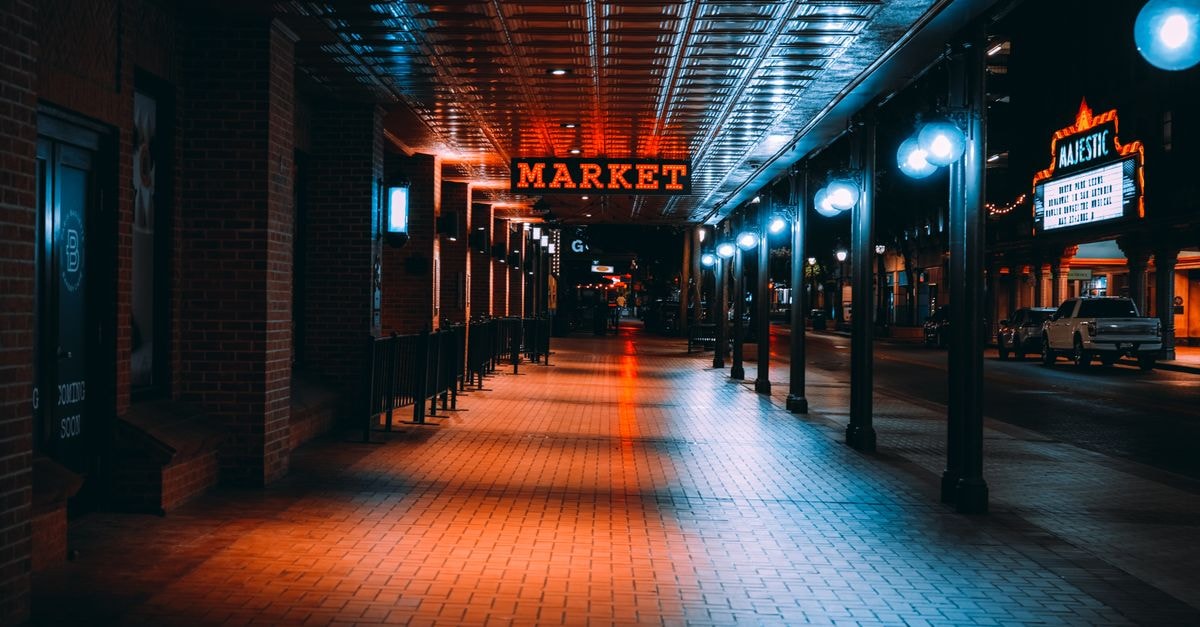 Colorful night view of San Antonio Market with bright lights and reflections.