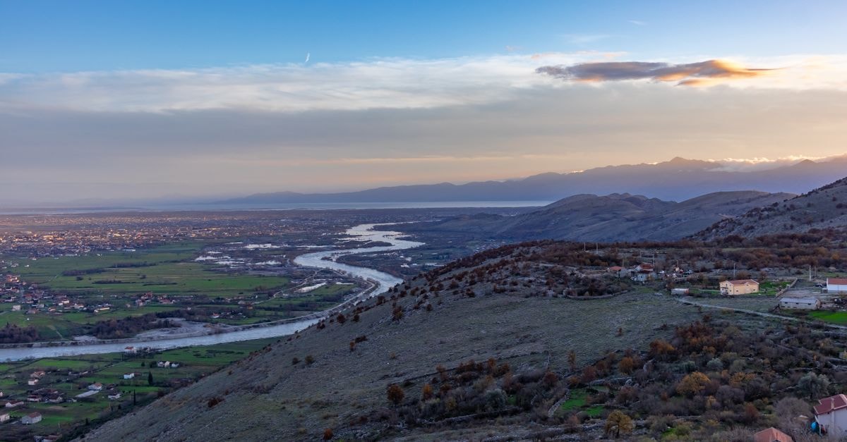Hotel Hemera in Podgorica: Rustic Industrial Boutique Charm Beautiful landscape of Podgorica, Montenegro, showcasing a river meandering through the valley at sunset.