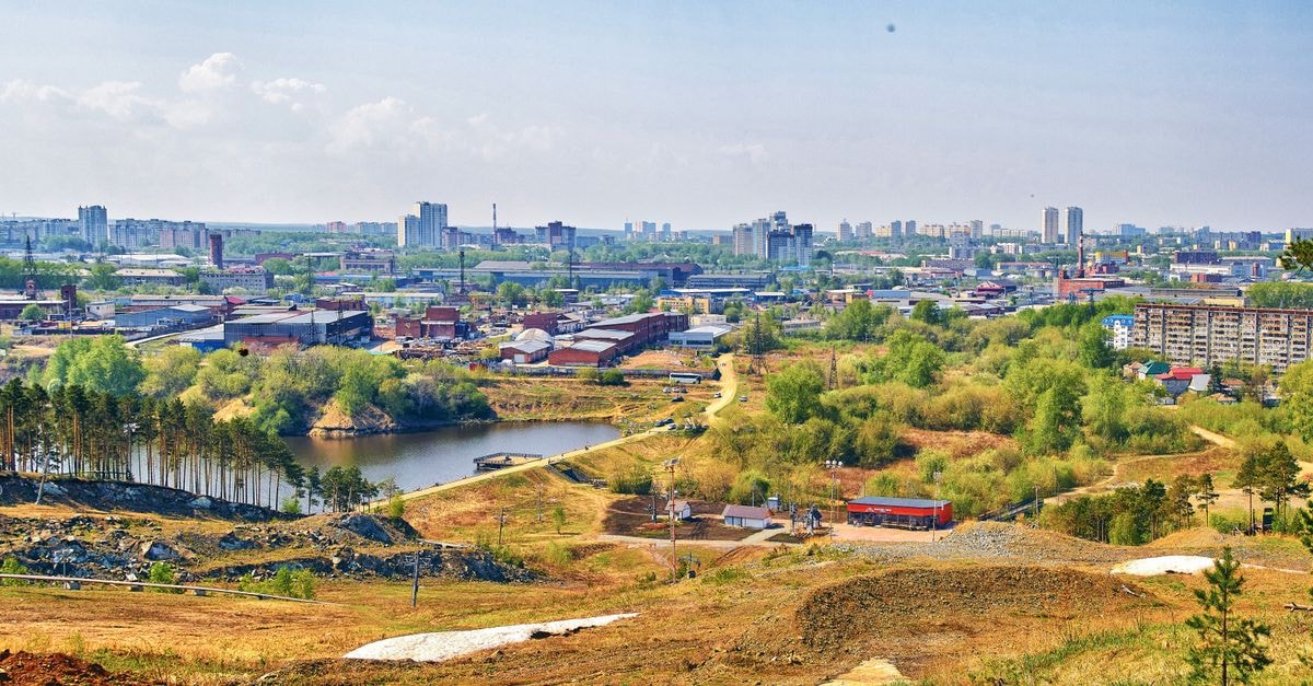 Coliseum Hotel in Khmelnytskyi: A Bright Hotel-Restaurant Complex Panoramic aerial view of a cityscape with a lake, surrounded by lush greenery and urban architecture.