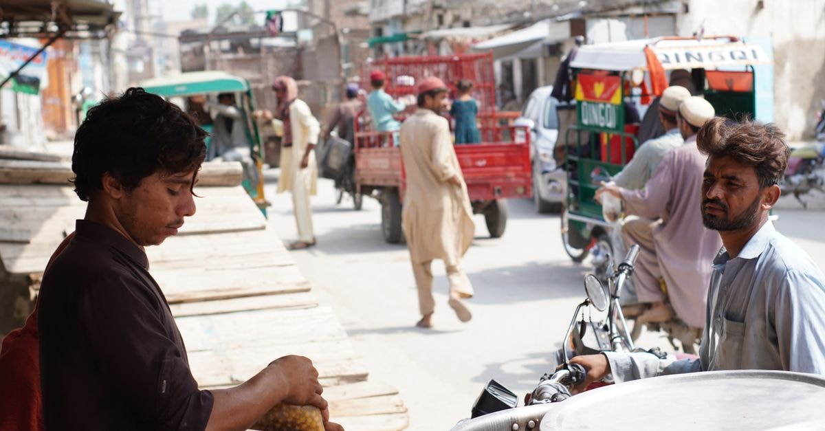 Multan Travel Guide: Sufi Shrines, Old Bazaars, and Street Food Street vendor selling food in bustling Nowshera, Pakistan. Urban life depicted with locals.