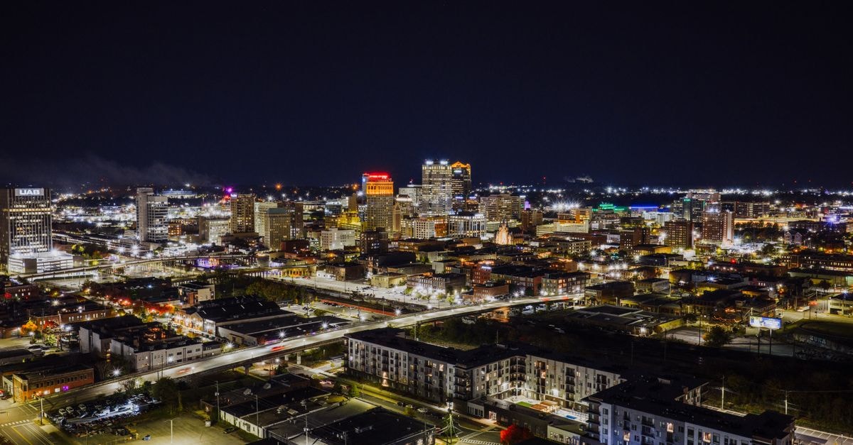 Stunning aerial night view of Birmingham, Alabama with illuminated cityscape and skyscrapers.