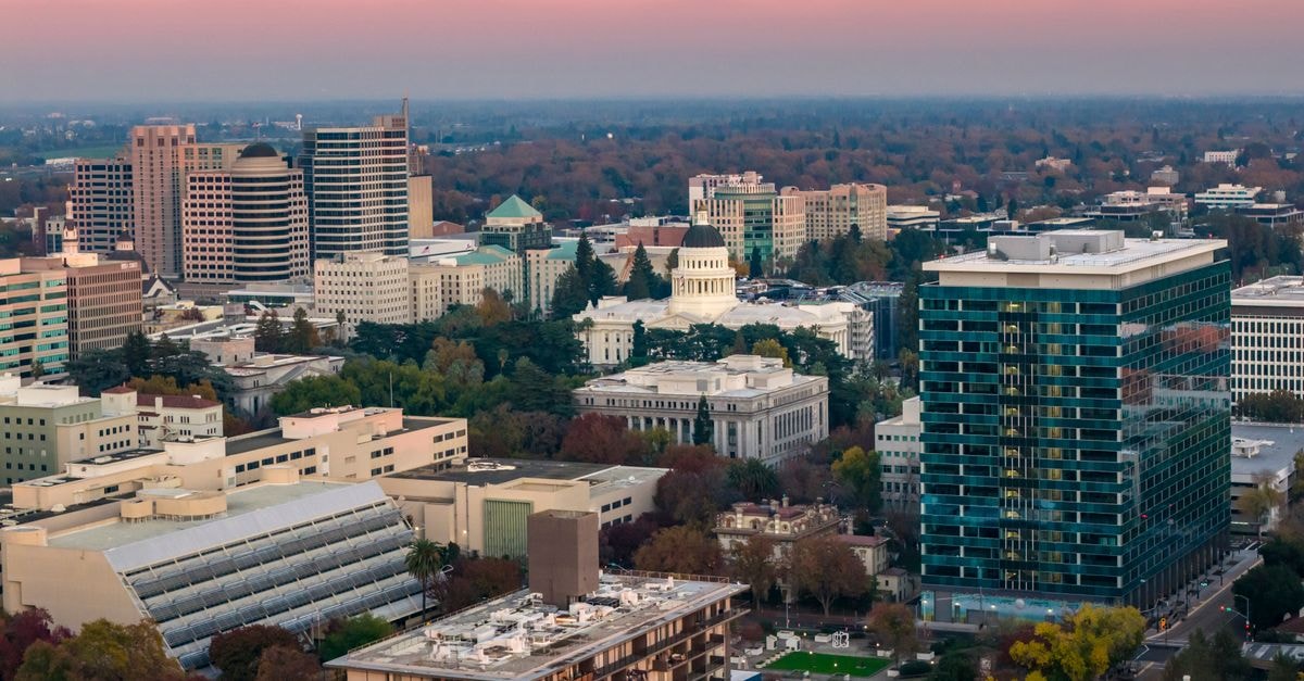 Aerial view of Sacramento skyline featuring the iconic California State Capitol at sunset.