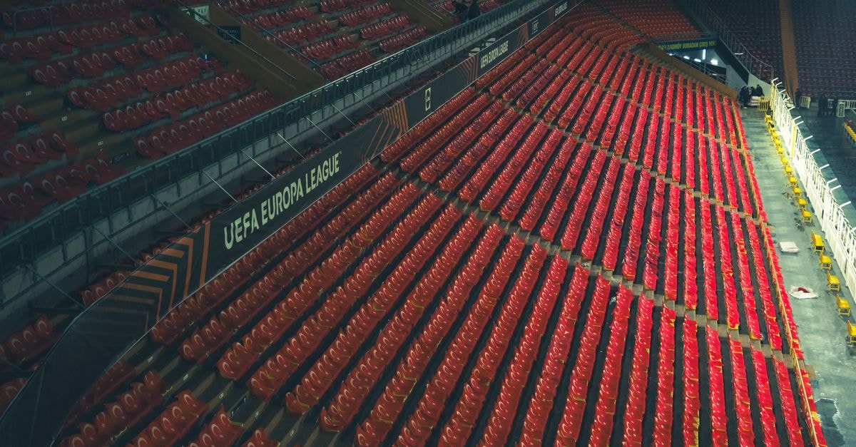Former Welsh first minister Carwyn Jones joins Scarlets board as WRU trims pro tier Rows of red seats in an empty stadium with UEFA Europa League signage.