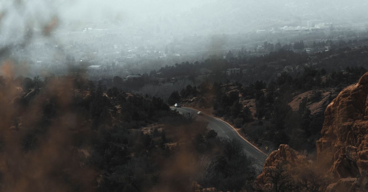 Hyatt Place Colorado Springs: Downtown Base Near Garden of the Gods Aerial view of a winding mountain road through misty landscapes in Colorado Springs, CO.