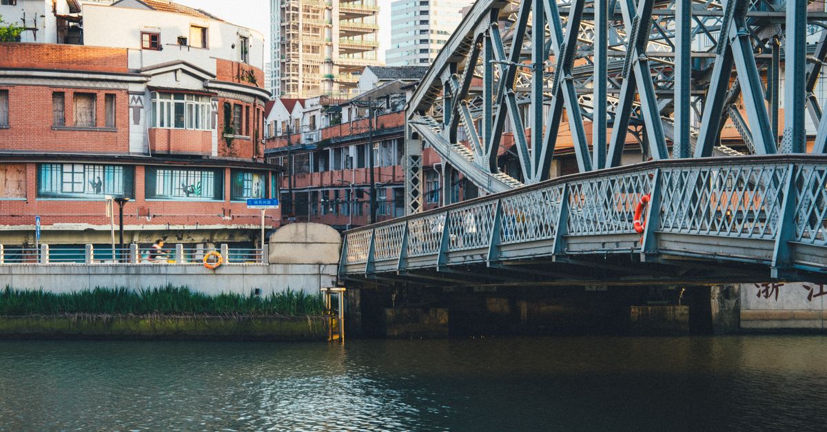 DeepSeek Readies Mainland China IPO as Second Funding Round Pushes Valuation to $71 Billion View of a historic steel bridge against an urban backdrop by the water.