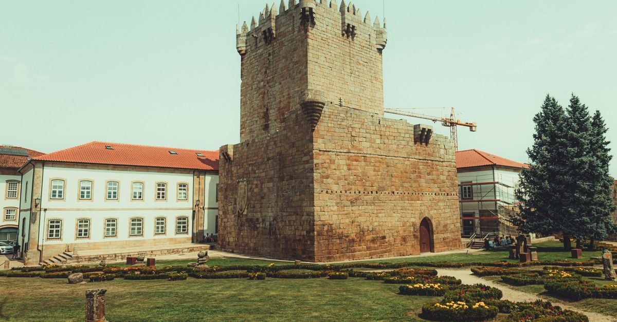 Castelo Branco Travel Guide: Planning Tips, Costs and Things to Do Medieval stone tower surrounded by gardens under a clear sky, showcasing European architecture.