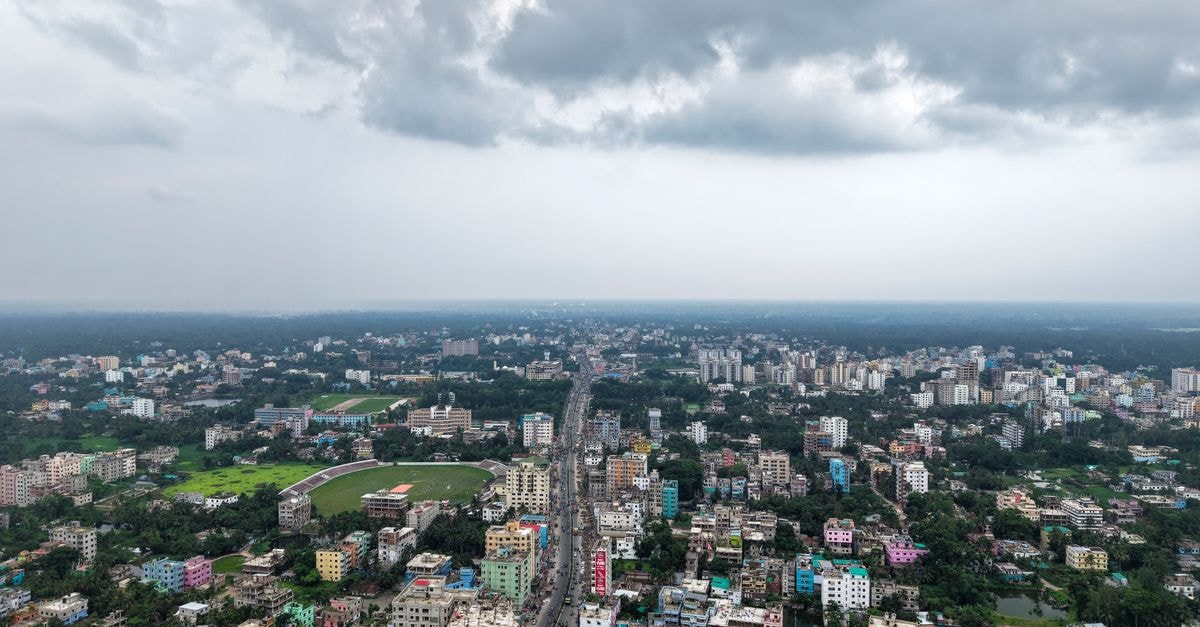 Latika Lodge, Asansol — A Quiet Stay Steps from Asansol Junction Aerial photo of a sprawling cityscape with diverse buildings and a cloudy sky, showcasing urban life.