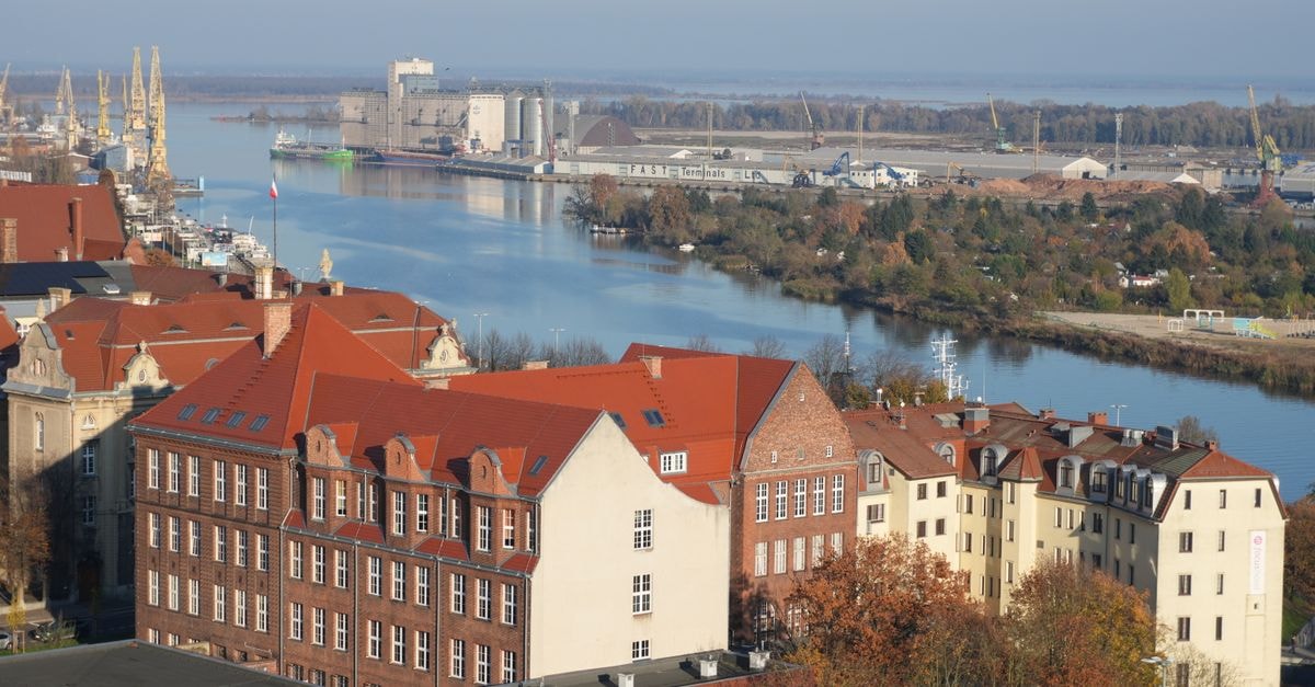 Aerial view of red-roofed buildings and a river landscape in an urban setting.