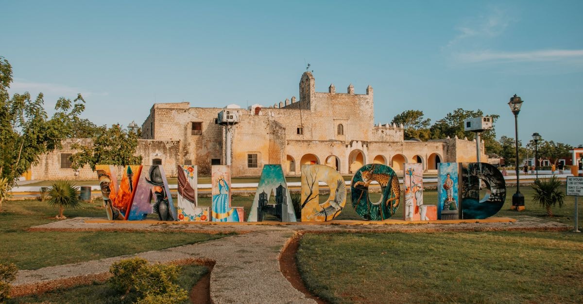 Governador Valadares Travel Guide: Planning Tips, Costs and Things to Do Vibrant Valladolid letters in front of a historic convent in Mexico, surrounded by greenery.