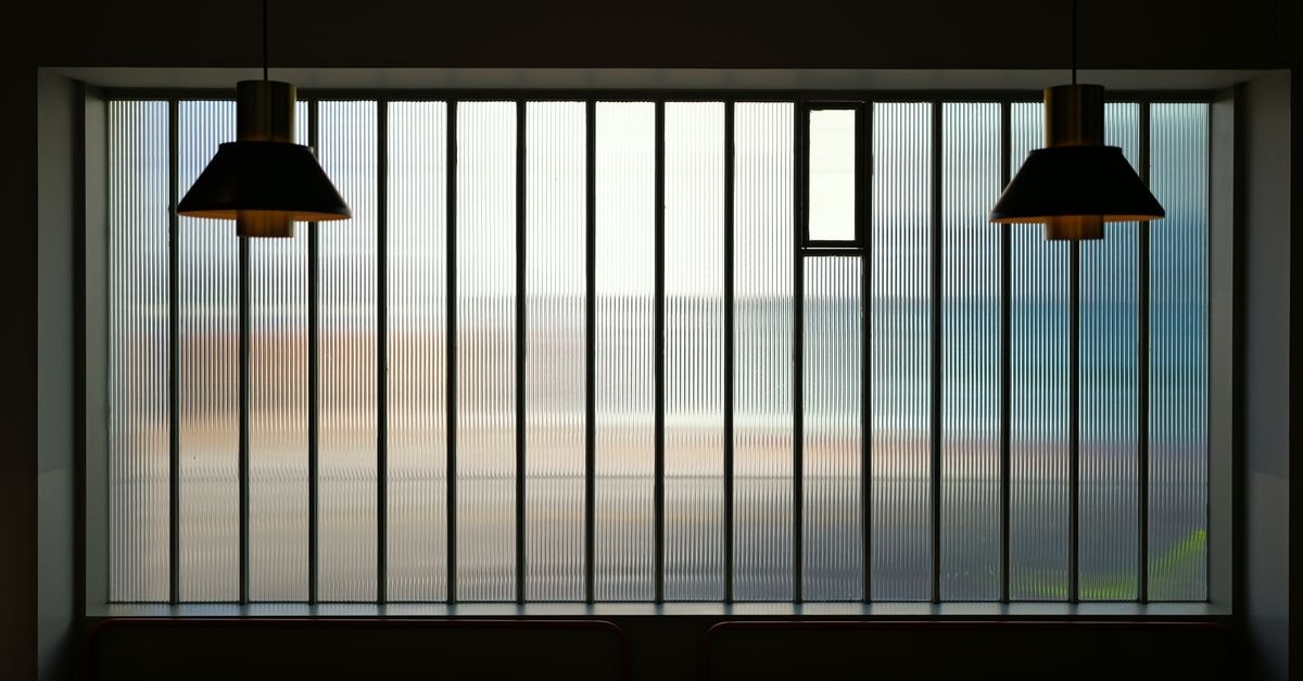Modern indoor setting with pendant lights and a ribbed glass window providing ambient lighting.