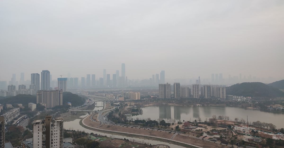 Old Street International Youth Hostel, Changsha — Duzheng Street Setting Aerial view of a foggy Changsha skyline with a river and modern buildings.