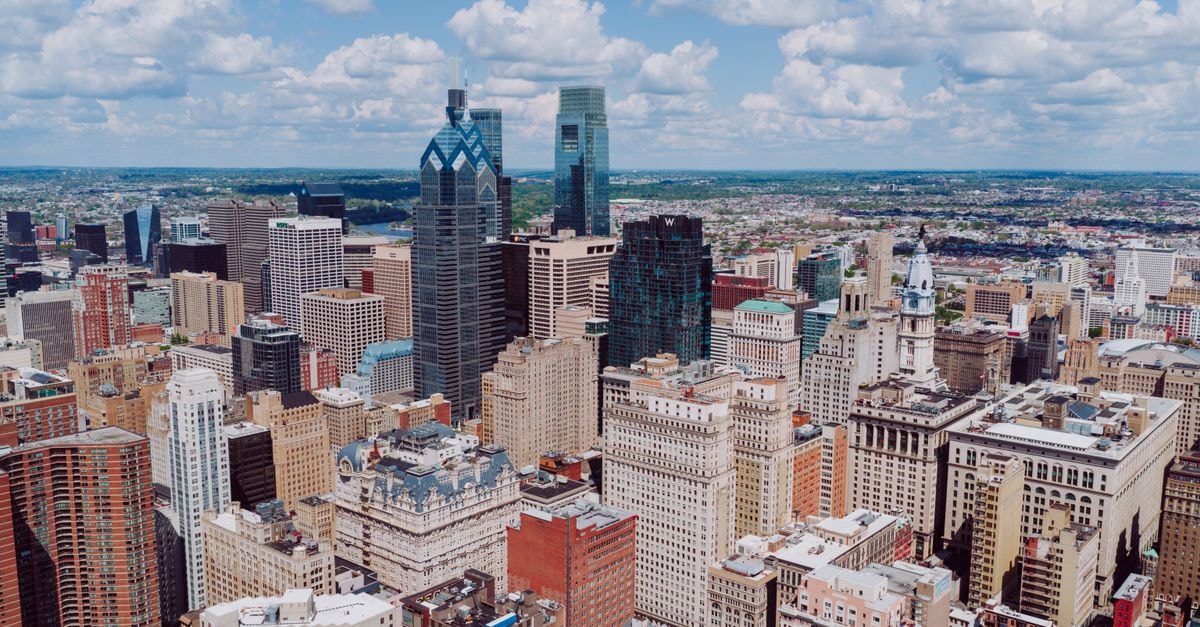 Breathtaking aerial view of the Philadelphia skyline, showcasing iconic skyscrapers and buildings under a blue sky.