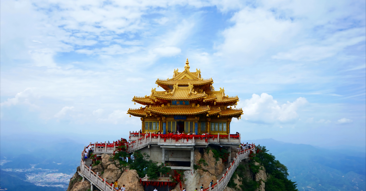 Zhumadian Travel Guide: Temples, Granite Arches, and a Southern Henan Crossing Golden temple perched on top of a mountain in Luoyang, China, surrounded by clear skies and scenic views.