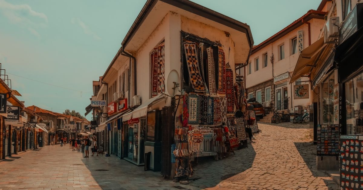 Kumanovo Travel Guide: Quiet Corners and Local Flavor in North Macedonia Bustling market street in Skopje with vibrant textiles and historic architecture.