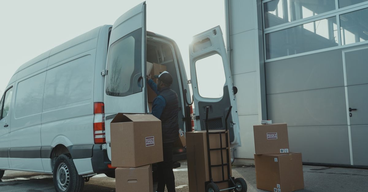 BJ's Wholesale Club: Growth at a Price That Already Asks for It Courier loading cardboard boxes into a delivery van outside a warehouse.