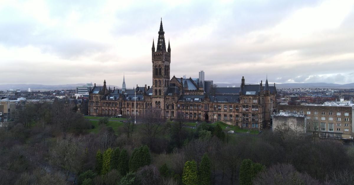 Kimpton Blythswood Square Hotel in Glasgow: Georgian Townhouses on a Leafy Square Drone shot of University of Glasgow with green trees and cloudy skies.