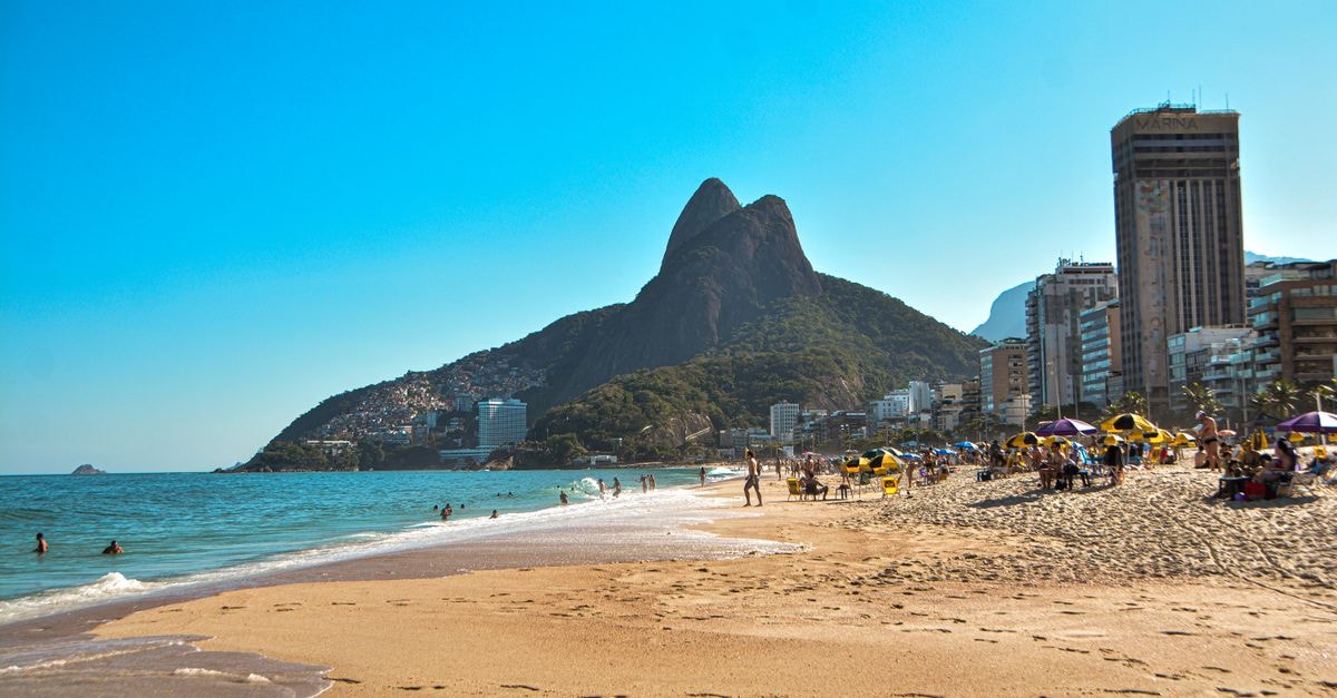 Rio de Janeiro Travel Guide: Beaches, Botanics, and BRT Scenic view of Ipanema Beach in Rio de Janeiro with mountains and city skyline.