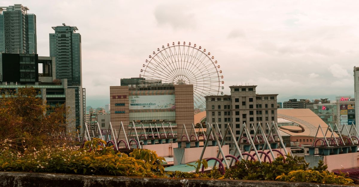 Captivating urban skyline featuring a large Ferris wheel surrounded by modern skyscrapers.
