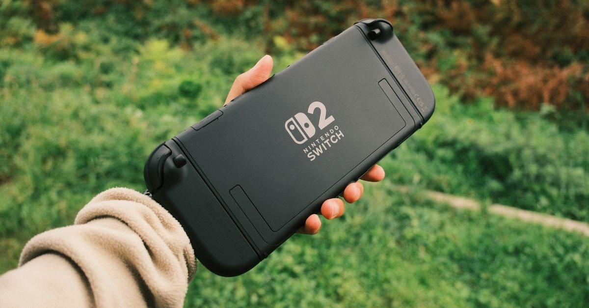 Nintendo Sets Aug. 4 Direct Showcase for Fire Emblem: Fortune's Weave Person holding a Nintendo Switch in a natural outdoor setting, perfect for on-the-go gaming.