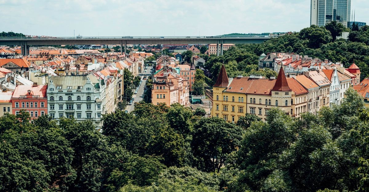 Charming cityscape showcasing colorful buildings and lush greenery under a bright sky.