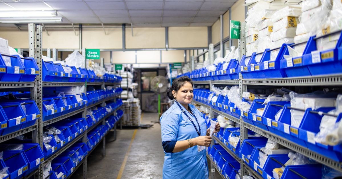 McKesson to acquire Precision Medicine Group for $2.25bn Female worker organizing inventory in a warehouse with blue bins and bright lighting.