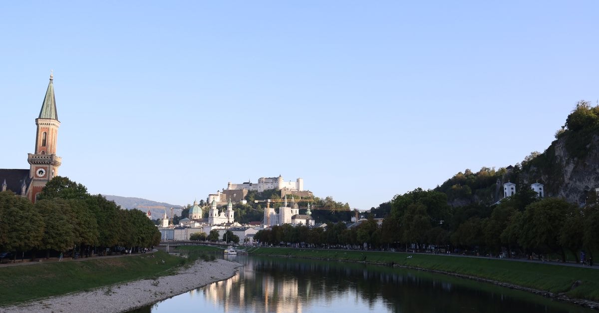 Charming view of Hohensalzburg Fortress over the Salzach River in Salzburg, Austria during the day.