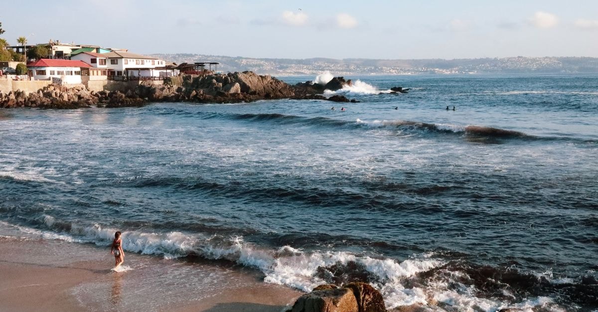 Tranquil ocean view from Las Cruces beach, Chile, featuring waves and coastal houses.