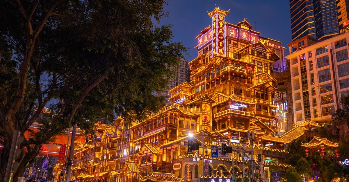 Zigong Travel Guide: Salt, Spice, and an Off-the-Beaten-Path Sichuan Story Stunning view of the illuminated Hongyadong complex in Chongqing at nighttime, showcasing vibrant urban architecture.