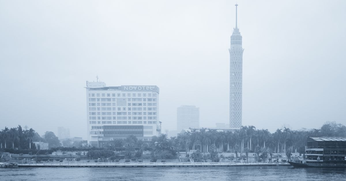 Brassbell in Cairo: Fully-Serviced Apartments on Talaat Harb Street Foggy cityscape of Cairo featuring the Cairo Tower and Novotel by the Nile River.
