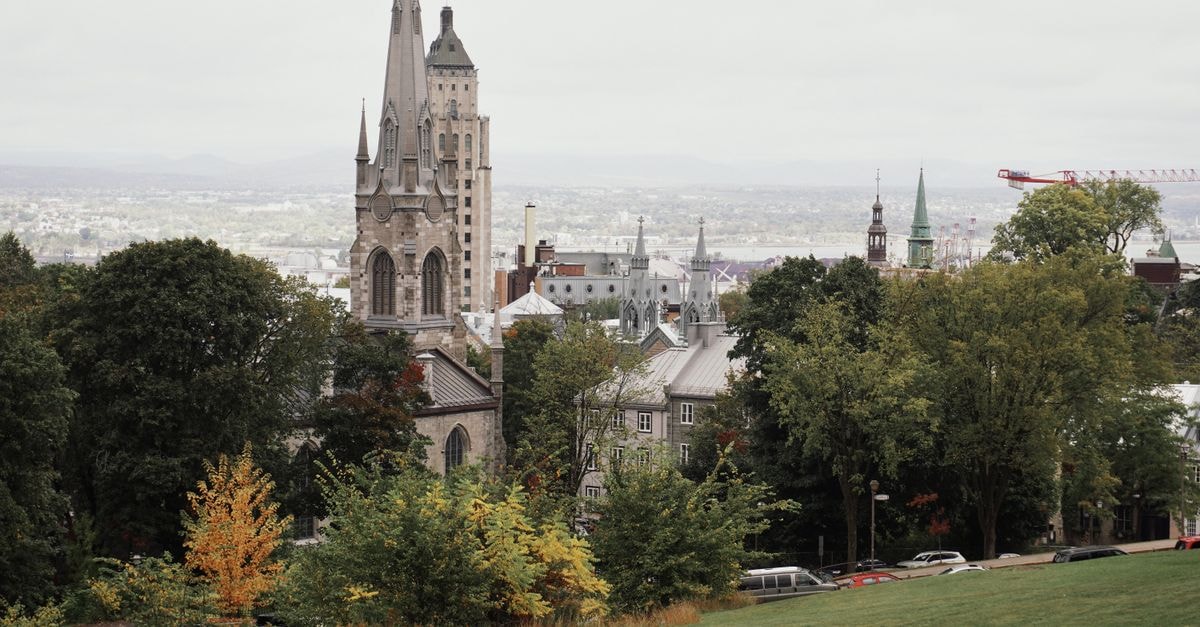 A picturesque view of Quebec City featuring its historic church with autumn foliage.