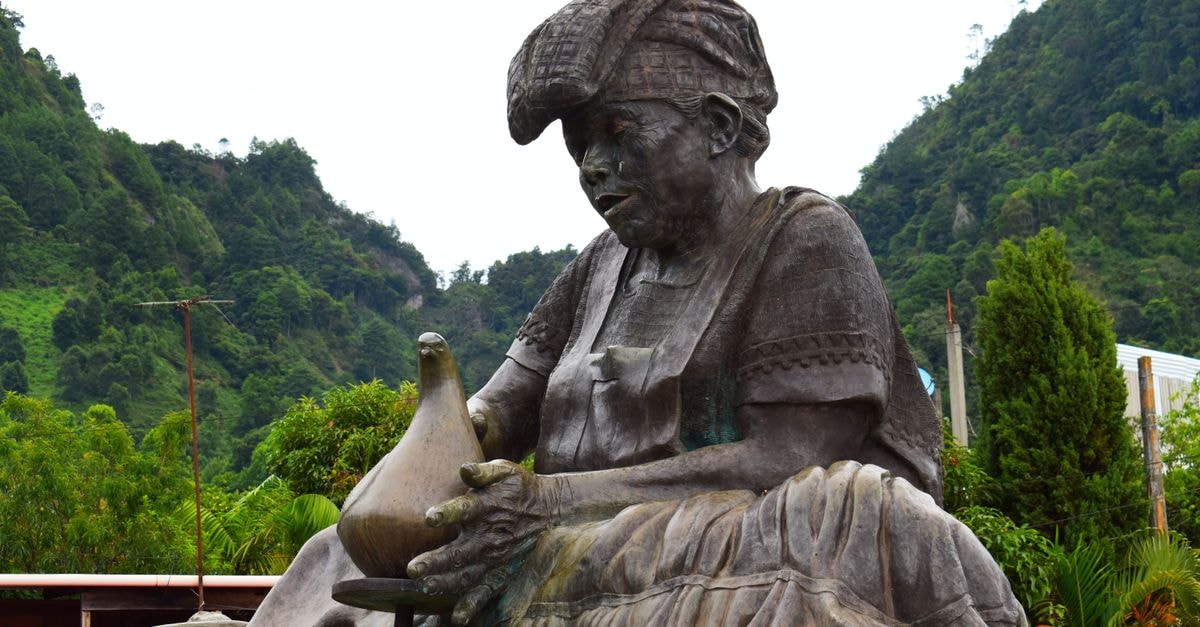 Hagåtña Travel Guide: Pacific's First European Capital Close-up of an expressive statue set against lush greenery, capturing cultural essence.