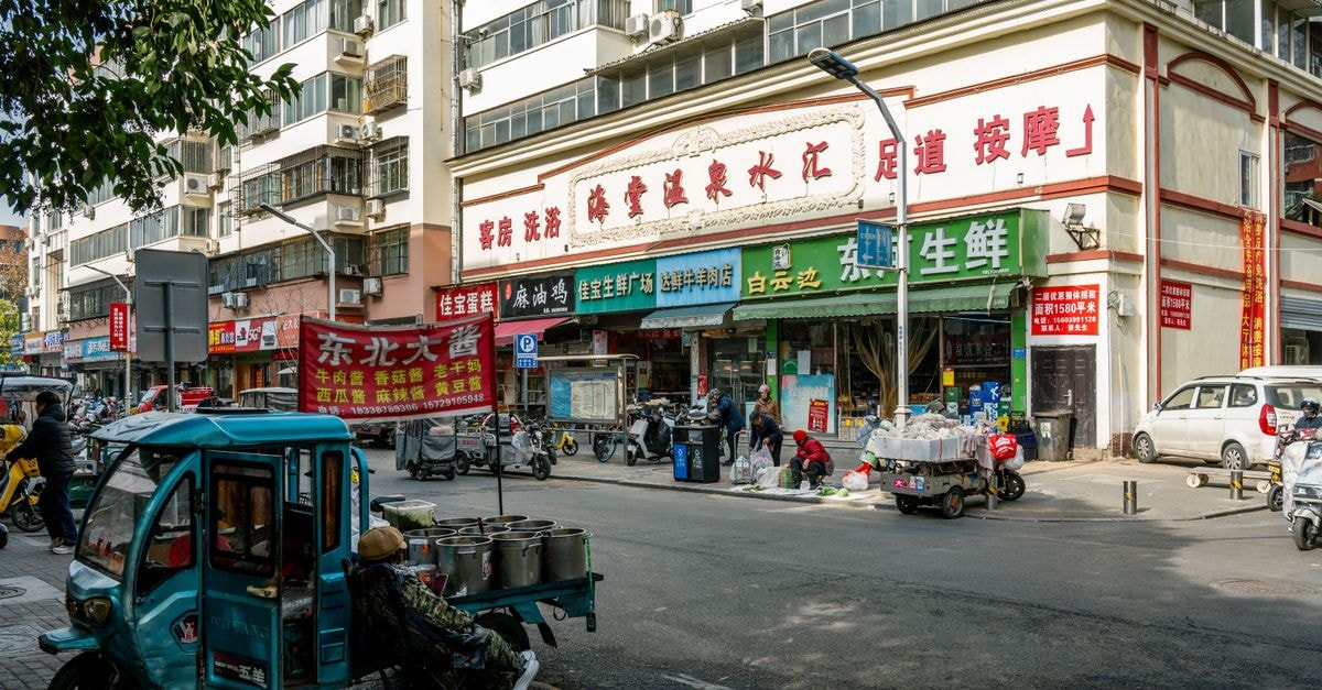 7 Days Inn Luoyang Jiudu Road: A Relaxed Stop Near Heritage Luoyang Street view capturing daily life and activities in Luoyang, China, showcasing local businesses and urban traffic.