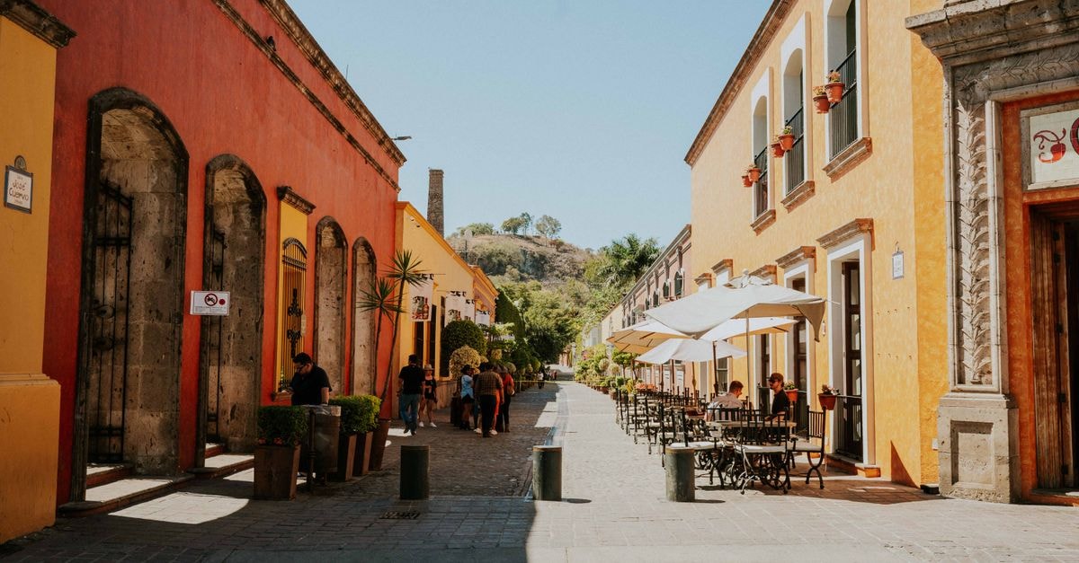 Colorful street scene in Tequila, Jalisco, showcasing vibrant buildings under a clear sky.
