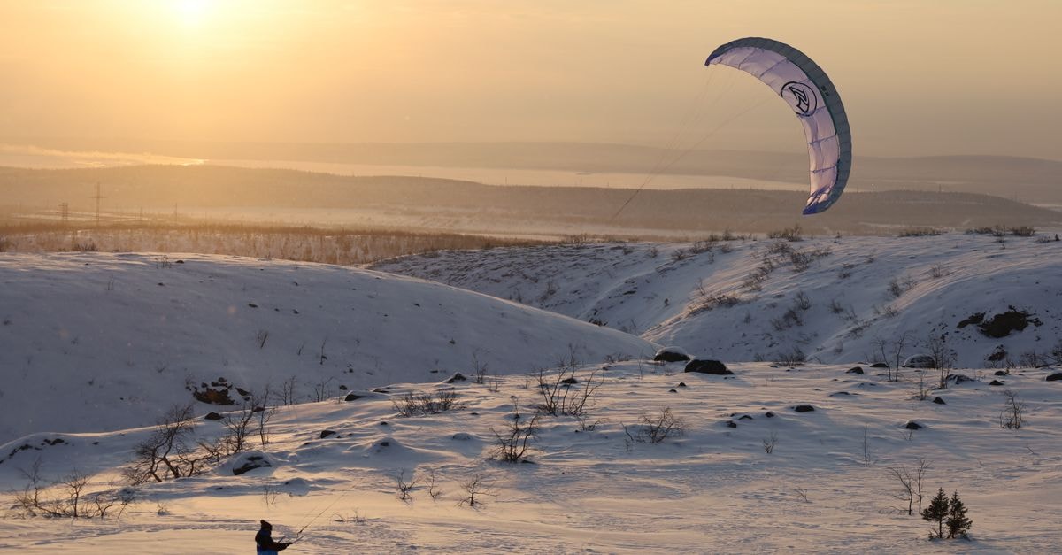 Murmansk Travel Guide: Arctic Gateway Essentials A kiteboarder enjoys snowkiting in the winter landscape of Murmansk, Russia.