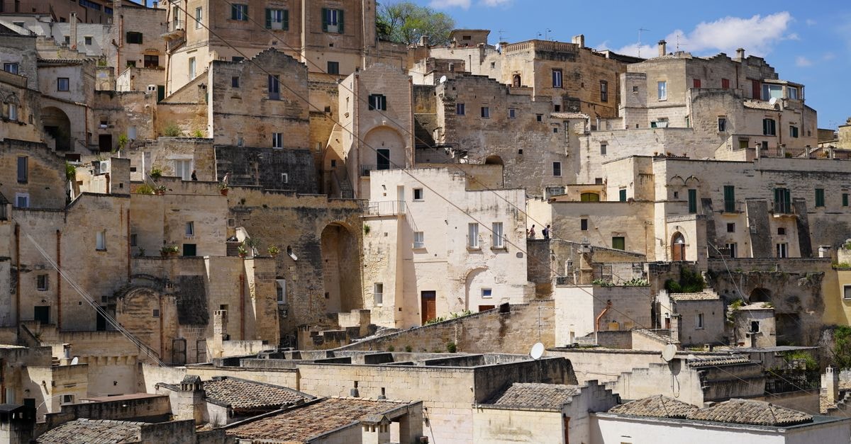 Palazzo della Fontana Urban Hotel in Matera: Retro Building, Walkable Old Town A scenic view of the ancient stone cityscape in Matera, Italy, under clear skies.