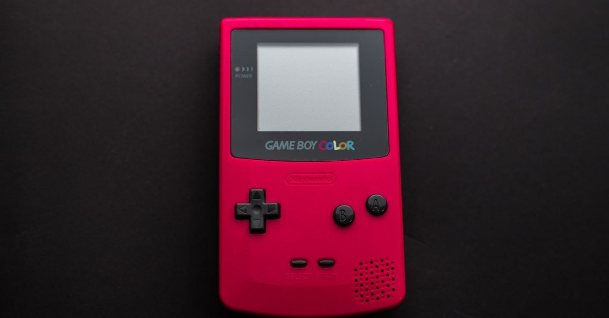 Close-up of a red Nintendo Game Boy Color on a dark backdrop, showcasing retro gaming nostalgia.