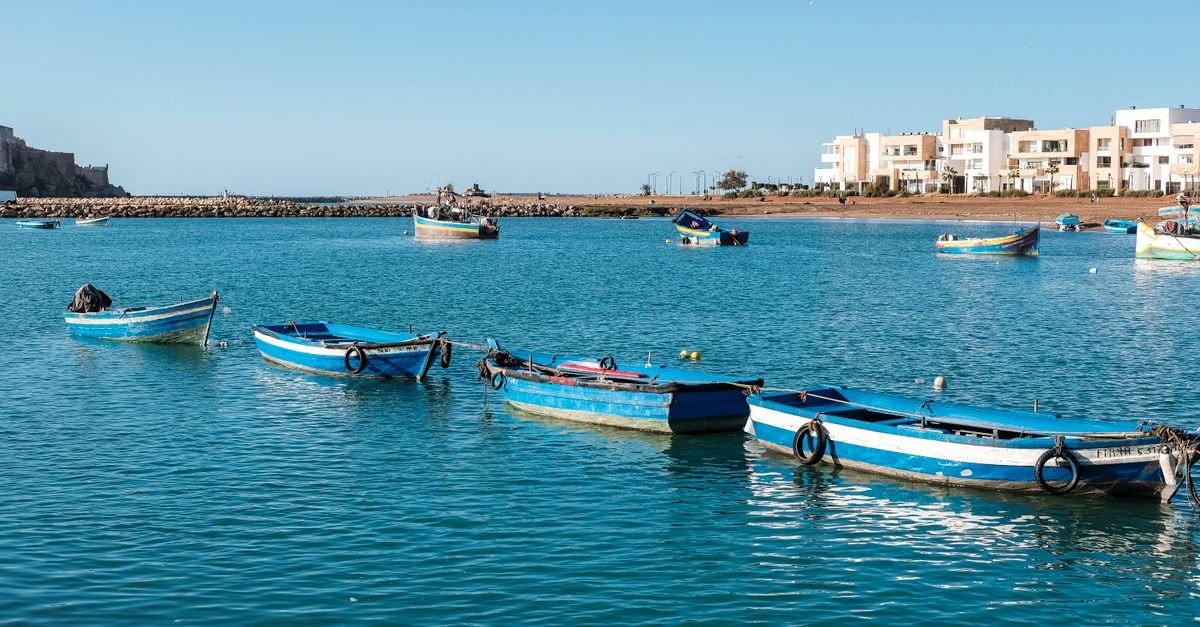 Rabat travel guide: a quiet coastal capital worth slowing down for Peaceful scene of colorful boats on Rabat's coastline under a bright blue sky.
