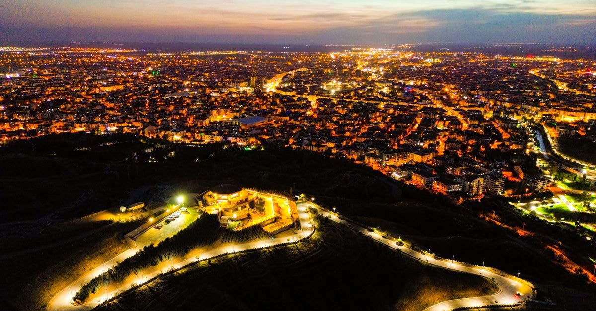 Hampton by Hilton Istanbul Zeytinburnu: Metro-Steps from the Old Town Stunning aerial view of a brightly lit cityscape under twilight, showcasing urban life and architectural lights.