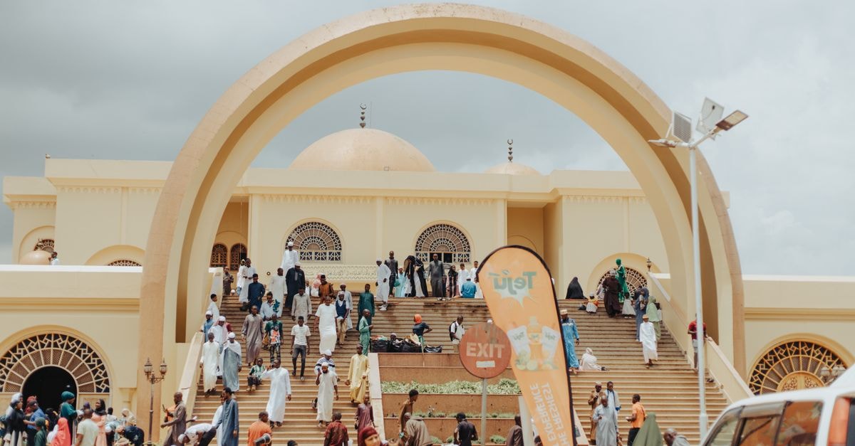 Hargeisa Travel Guide: Things to Do in Somaliland's Capital People gather at a mosque in Uganda, showcasing beautiful Islamic architecture under a cloudy sky.