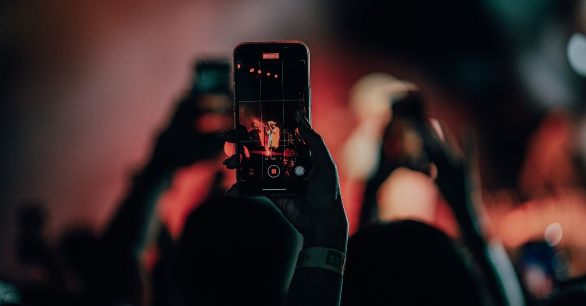 Rod Stewart cancels remaining 2026 US tour dates after coronary stent surgery A close-up of a smartphone recording a lively concert scene with colorful stage lights.