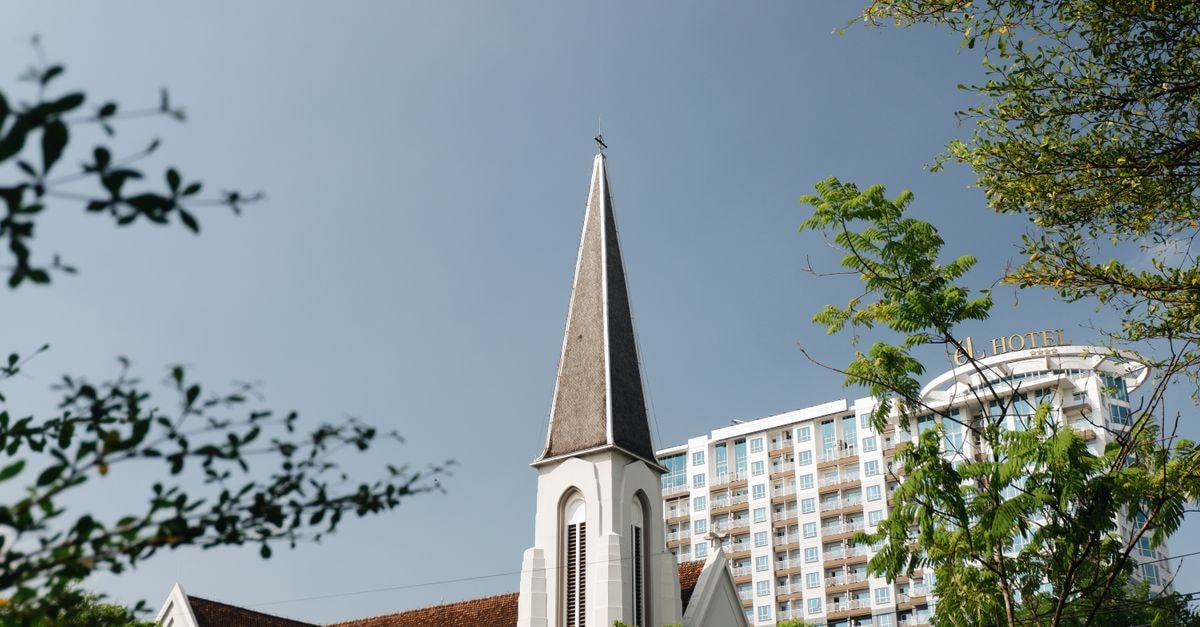 Bandung Travel Guide: Planning Tips, Costs and Things to Do A historic church steeple amidst modern buildings in Bandung, Indonesia.