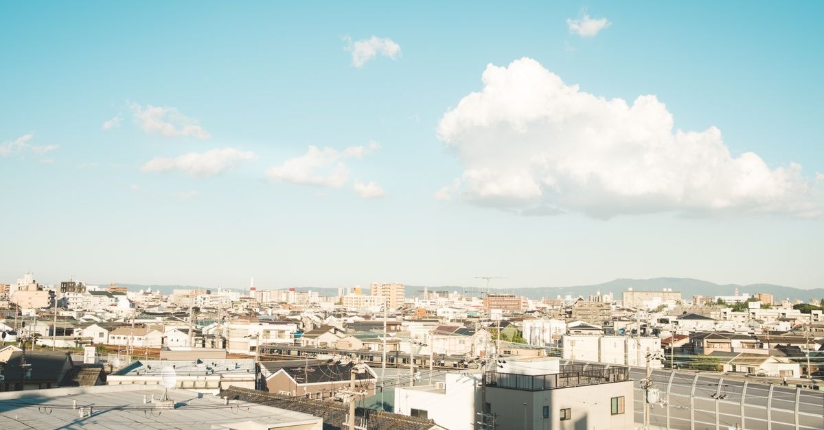 Daiwa Roynet Hotel Toyama Ekimae: 3-Minute Walk from the Station Wide-angle view of a city skyline under a bright, clear blue sky with scattered clouds.