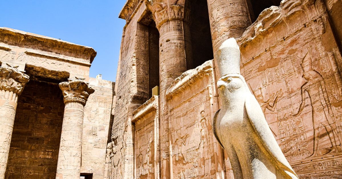 Explore the stunning ruins of an ancient Egyptian temple featuring iconic columns and a falcon statue.