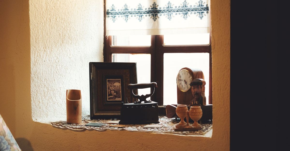 Hotel Antique in Pernik: Classic City-Center Base Near Vitosha Views A cozy indoor window sill decorated with vintage antiques and soft natural lighting.