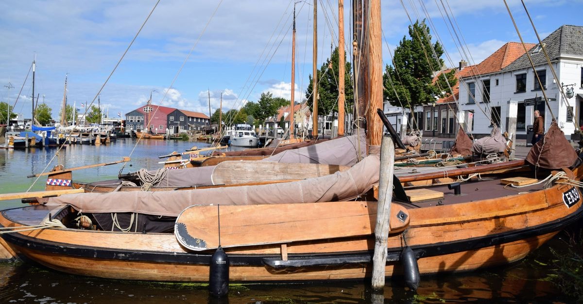 Groningen Travel Guide for August 2026: Planning Tips and Costs Charming traditional wooden boats docked in Elburg harbor, Gelderland on a sunny day.