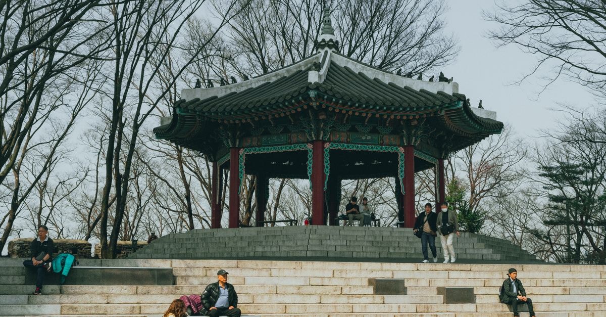 A serene scene of locals enjoying the picturesque traditional pavilion at Namsan Park in Seoul during spring.