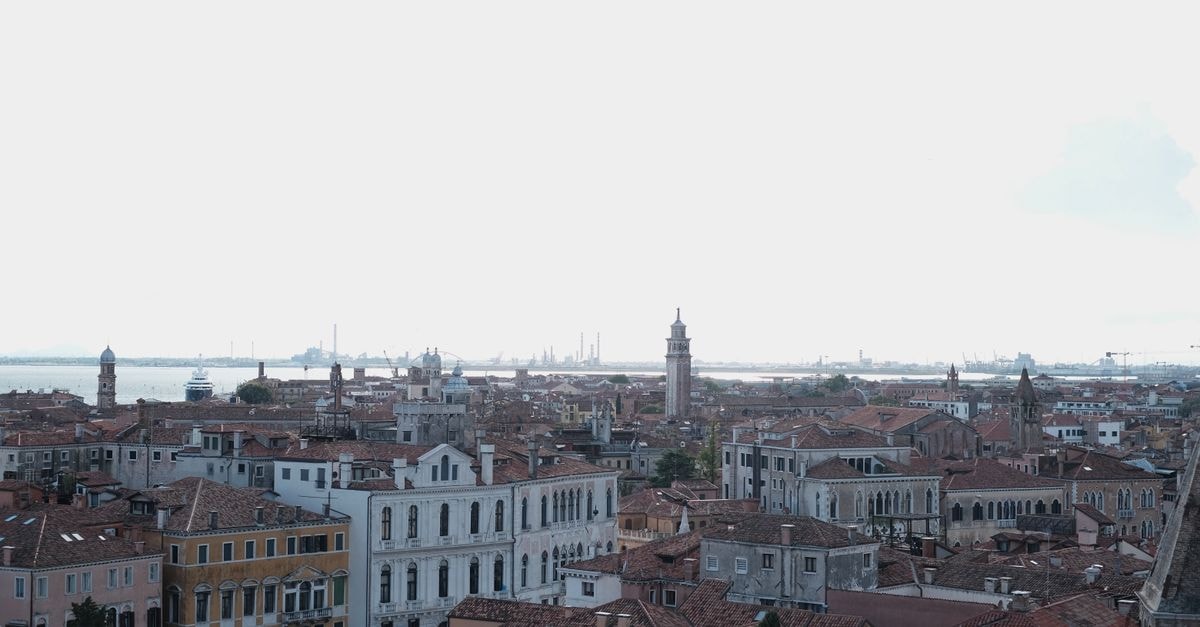 Ai Patrizi Venezia, Venice — Murano Chandeliers Near La Fenice Stunning aerial view of Venice showcasing historic buildings and a vibrant cityscape under a cloudy sky.