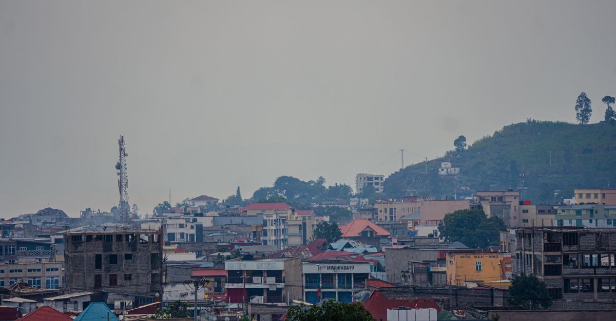 Hotel Amazonia in Coro: Avenida Independencia Base Elevated view of urban buildings with a hill backdrop under overcast skies, ideal for cityscape themes.