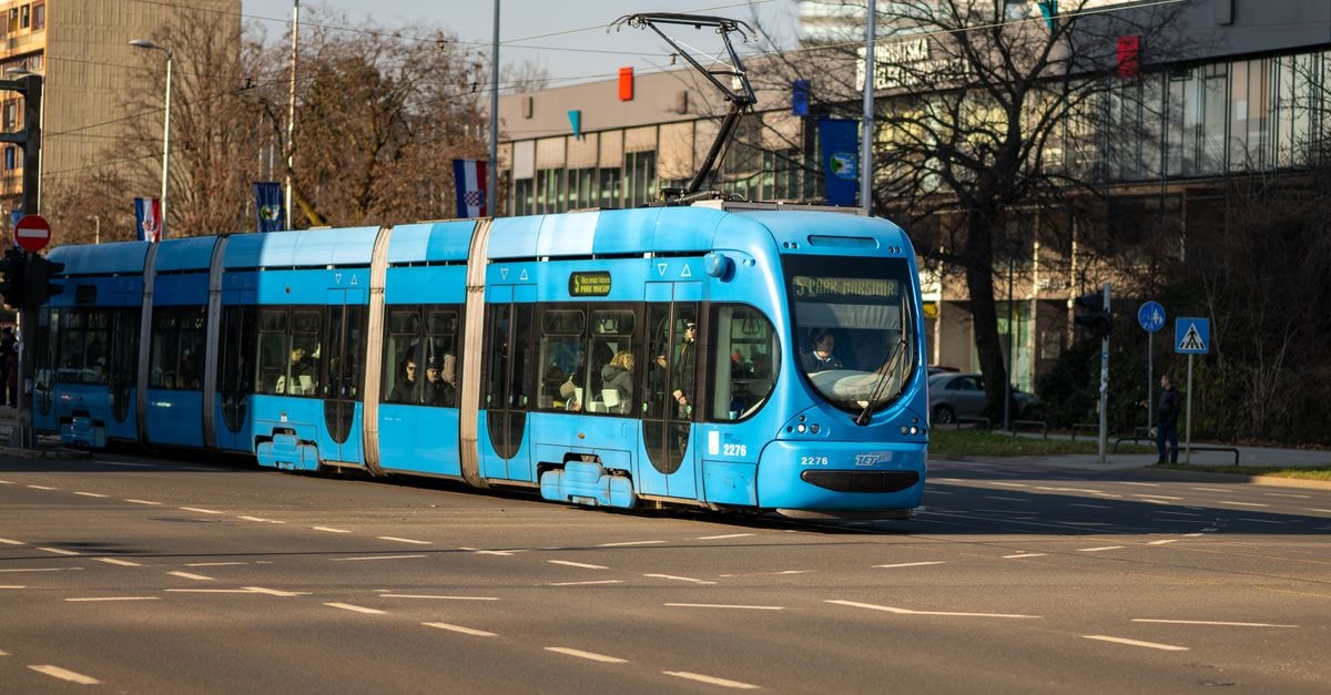 Zagreb travel guide: getting around, eating well, settling in A vibrant blue tram travels through the streets of Zagreb under a clear, sunny sky.