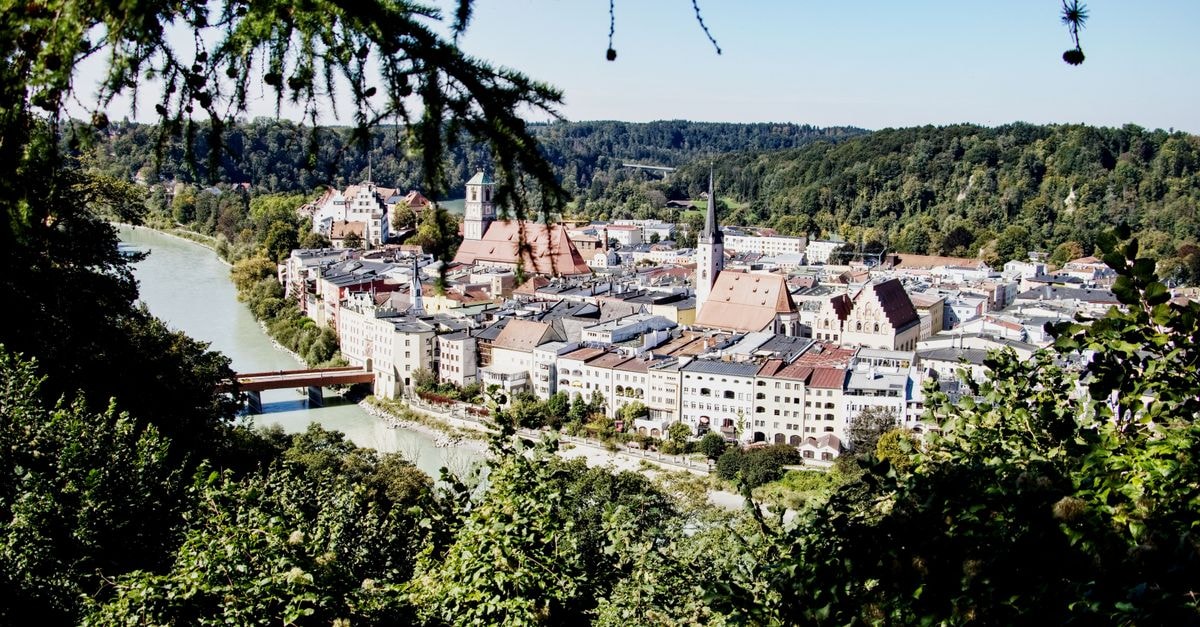 Augsburg travel guide: a quiet Bavarian city with deep roots A picturesque aerial view of the historic city of Wasserburg am Inn surrounded by lush greenery.